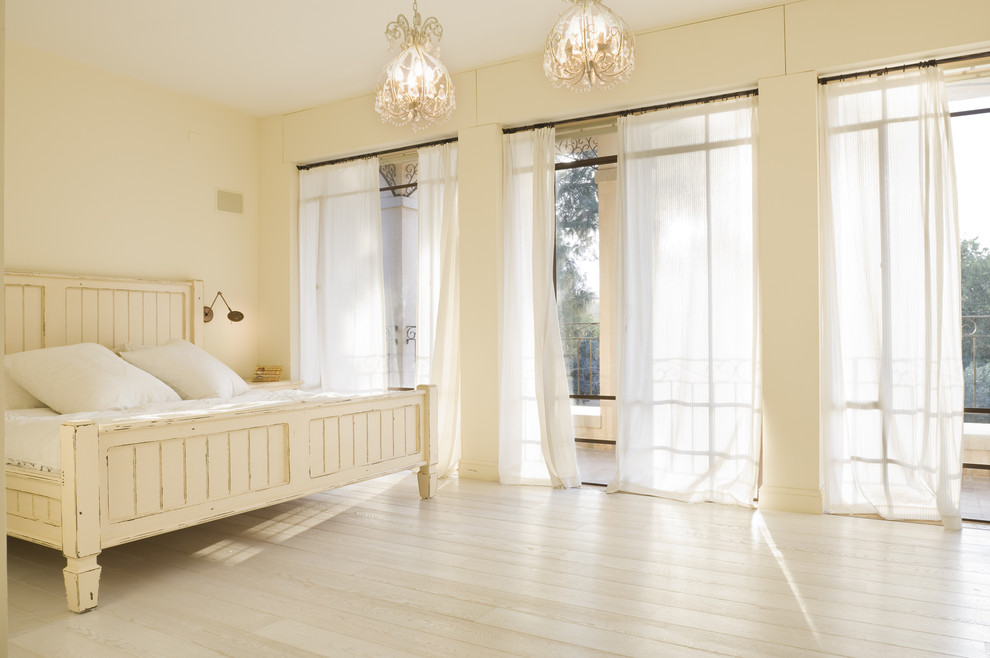 Inspiration for a mediterranean master bedroom in Tel Aviv with beige walls, light hardwood floors and beige floor.
