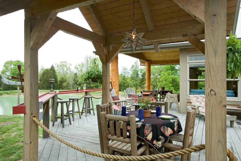 Large mountain style backyard deck photo with a pergola