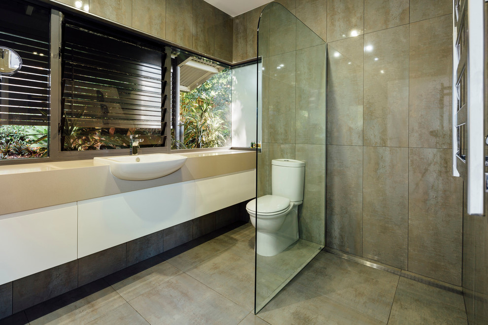 Inspiration for a mid-sized contemporary bathroom in Sydney with flat-panel cabinets, white cabinets, an open shower, a two-piece toilet, brown tile, stone tile, brown walls, ceramic floors, a console sink and solid surface benchtops.