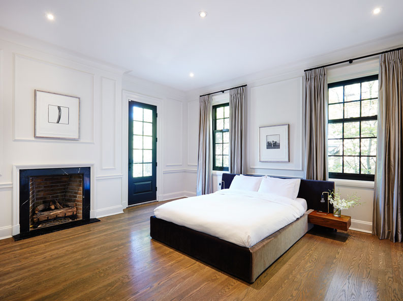 Photo of a large contemporary master bedroom in Montreal with brown walls, a standard fireplace, a stone fireplace surround, medium hardwood floors and brown floor.