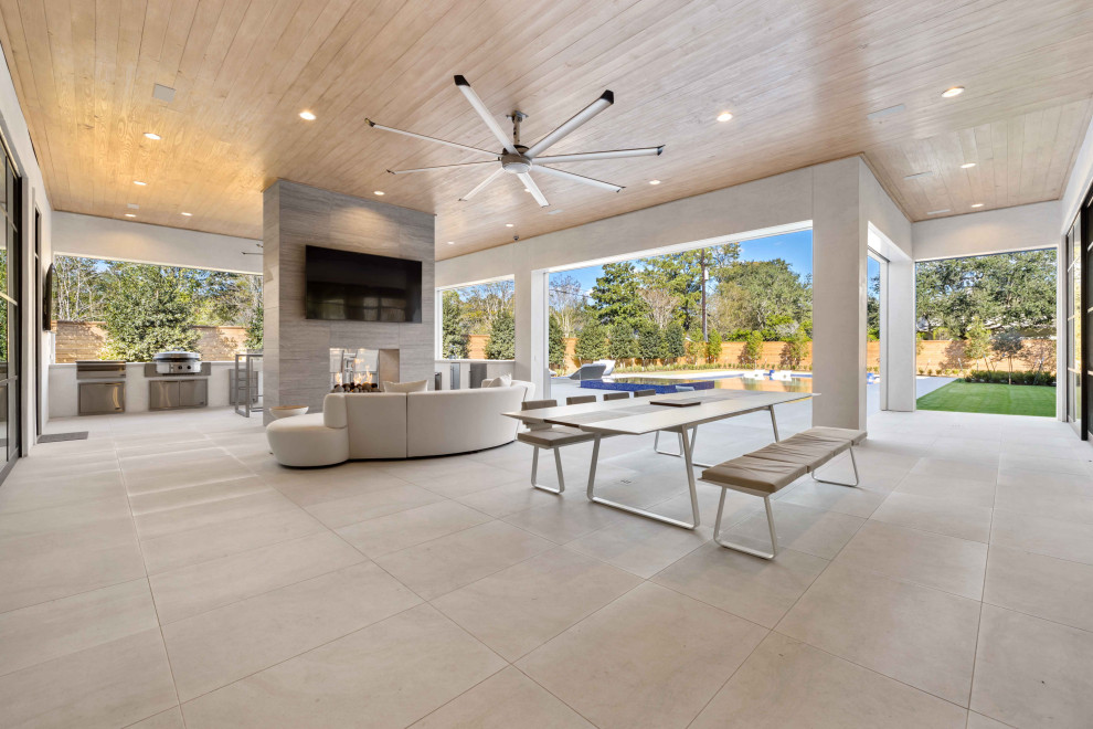 This is an example of an expansive contemporary back patio in Houston with an outdoor kitchen and tiled flooring.