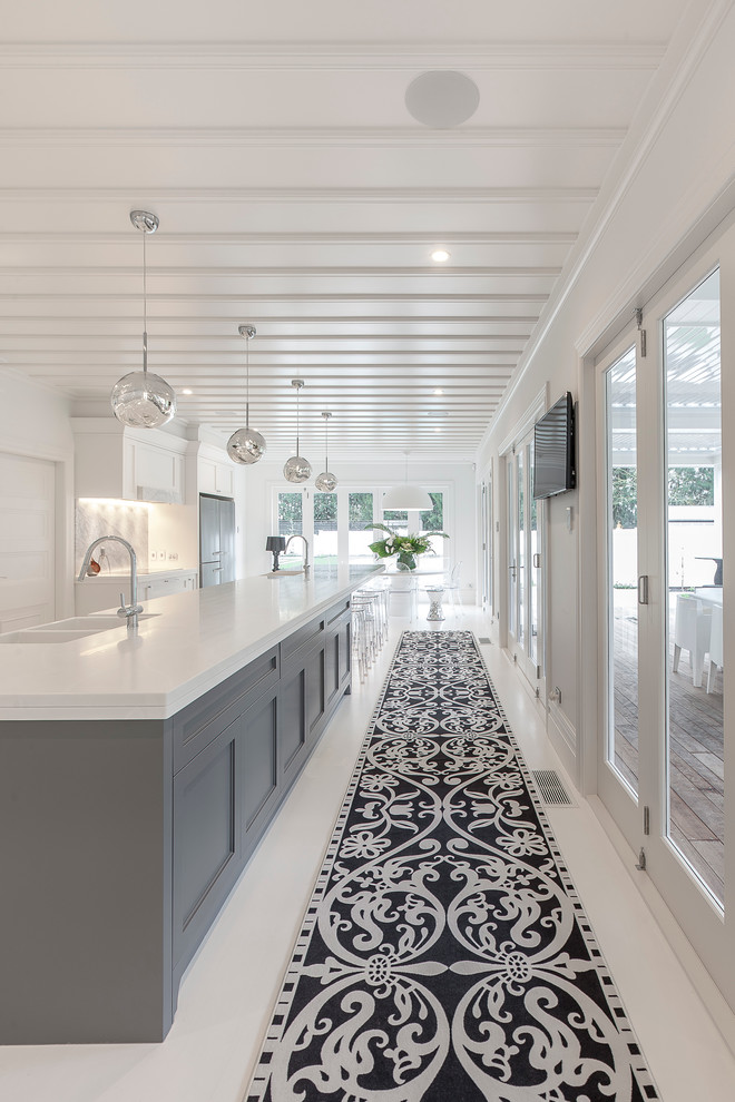 Design ideas for an expansive transitional eat-in kitchen in Auckland with a farmhouse sink, recessed-panel cabinets, white cabinets, solid surface benchtops, multi-coloured splashback, stone slab splashback, black appliances and with island.