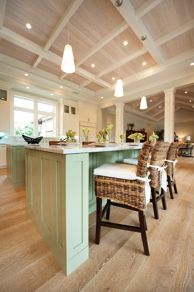 Example of a light wood floor kitchen design with stainless steel appliances and two islands