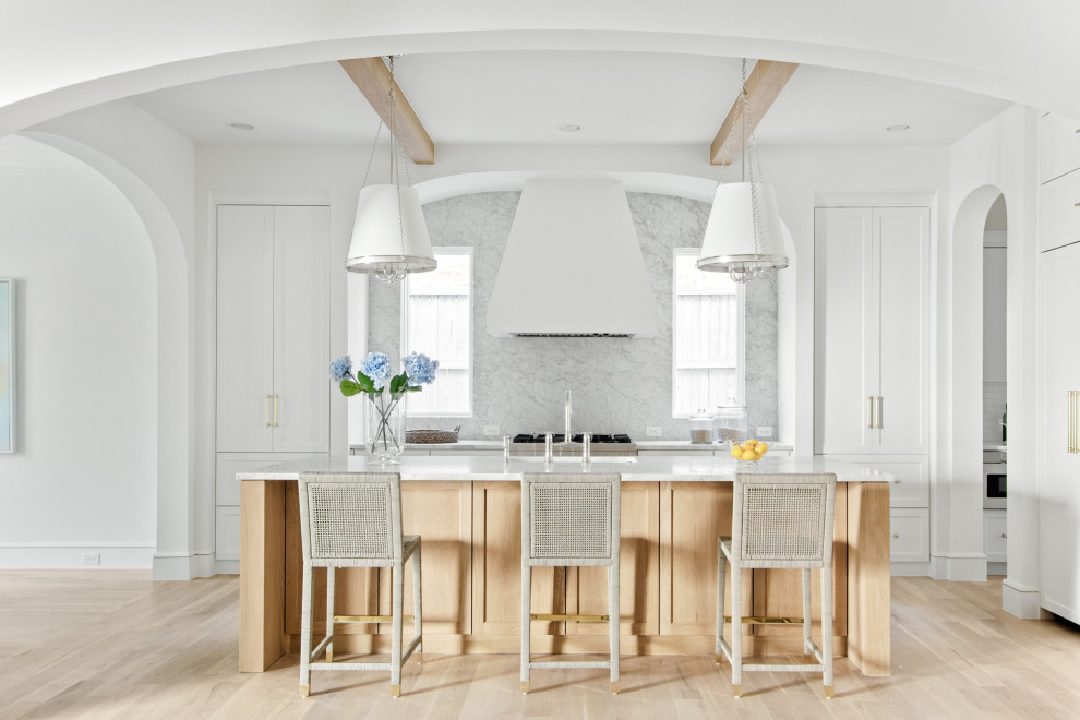 This is an example of a beach style single-wall kitchen/diner in Dallas with a submerged sink, shaker cabinets, white cabinets, marble worktops, grey splashback, marble splashback, stainless steel appliances, light hardwood flooring, an island, beige floors, grey worktops and exposed beams.