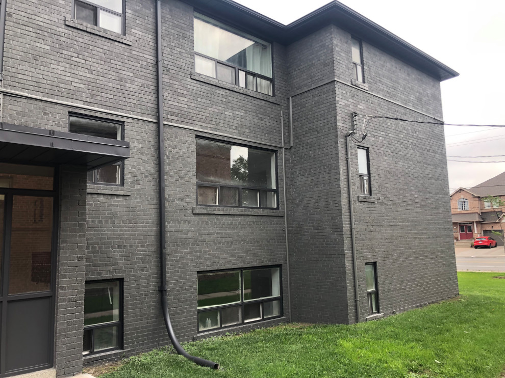 Ispirazione per la facciata di un appartamento grande grigio moderno a tre piani con rivestimento in mattoni