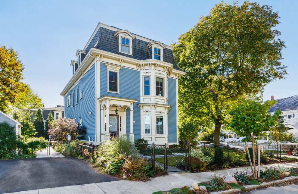 Mid-sized victorian three-storey blue duplex exterior in Boston with clapboard siding.