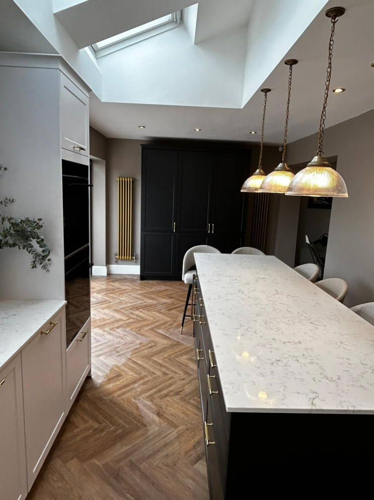 На фото: параллельная кухня среднего размера в классическом стиле с обеденным столом, фасадами в стиле шейкер, белыми фасадами и столешницей из кварцита