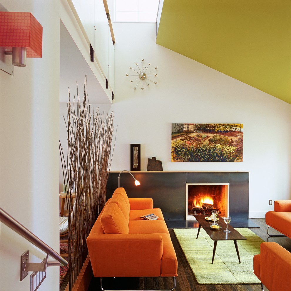 This is an example of a modern living room in DC Metro with white walls, dark hardwood floors and a standard fireplace.