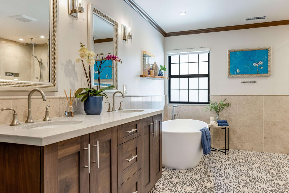 Стильный дизайн: ванная комната в средиземноморском стиле с фасадами в стиле шейкер, коричневыми фасадами, отдельно стоящей ванной, бежевой плиткой, разноцветным полом, разноцветной столешницей, тумбой под две раковины и встроенной тумбой - последний тренд