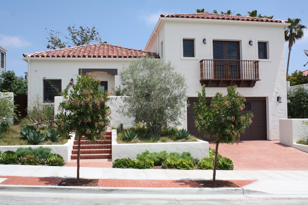 Photo of a large mediterranean two-storey stucco beige exterior in San Diego with a hip roof.