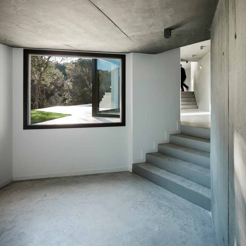 This is an example of a large contemporary concrete straight staircase in Barcelona with concrete risers.