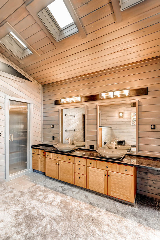 Inspiration for a mid-sized rustic master black tile and cement tile concrete floor corner shower remodel in Denver with flat-panel cabinets, light wood cabinets, a one-piece toilet, brown walls, a vessel sink and quartzite countertops