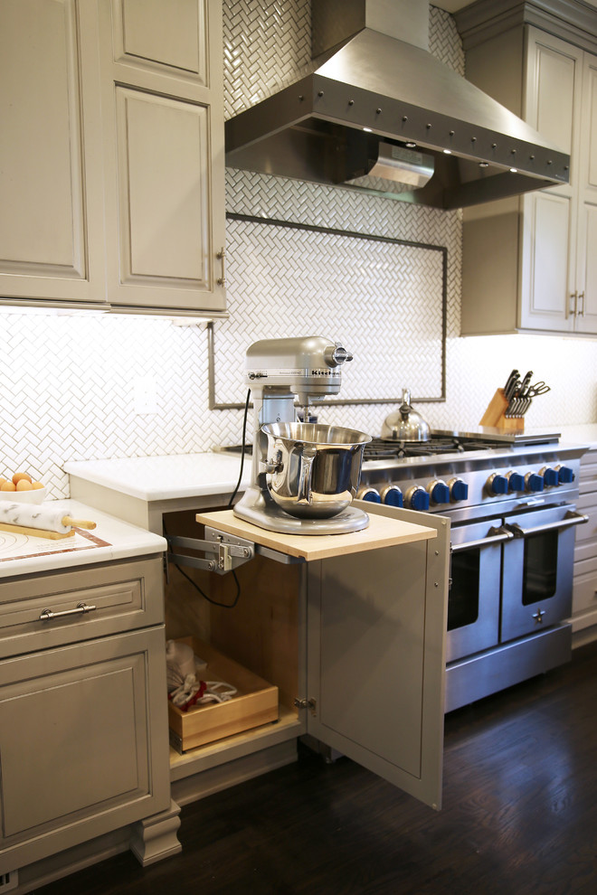 Inspiration for a large transitional l-shaped dark wood floor and brown floor enclosed kitchen remodel with raised-panel cabinets, white backsplash, ceramic backsplash, stainless steel appliances and an island