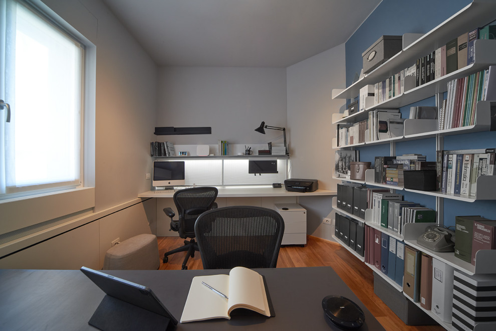 Idéer för ett mellanstort modernt hemmastudio, med blå väggar, mörkt trägolv och ett fristående skrivbord