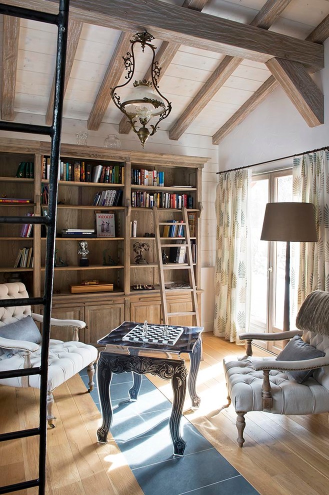 Traditional family room in Moscow with a library, white walls and light hardwood floors.