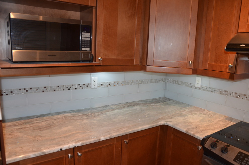 Home design - small transitional u-shaped porcelain tile home design idea in Toronto with a double-bowl sink, beaded inset cabinets, medium tone wood cabinets, granite countertops, white backsplash, glass tile backsplash, stainless steel appliances and no island
