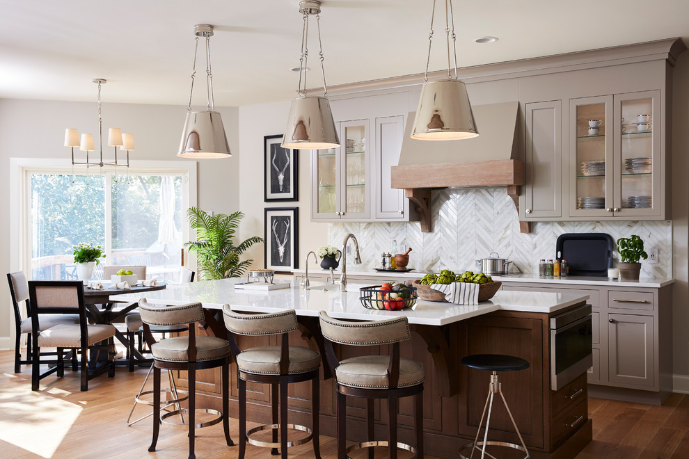 Inspiration for a large transitional eat-in kitchen in Minneapolis with an undermount sink, recessed-panel cabinets, grey cabinets, quartz benchtops, grey splashback, marble splashback, stainless steel appliances, medium hardwood floors, with island, brown floor and white benchtop.
