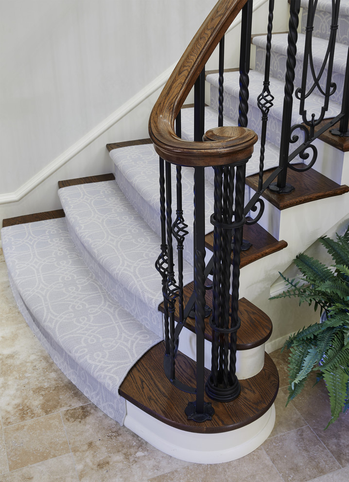 Large traditional staircase in Minneapolis with wood railing.