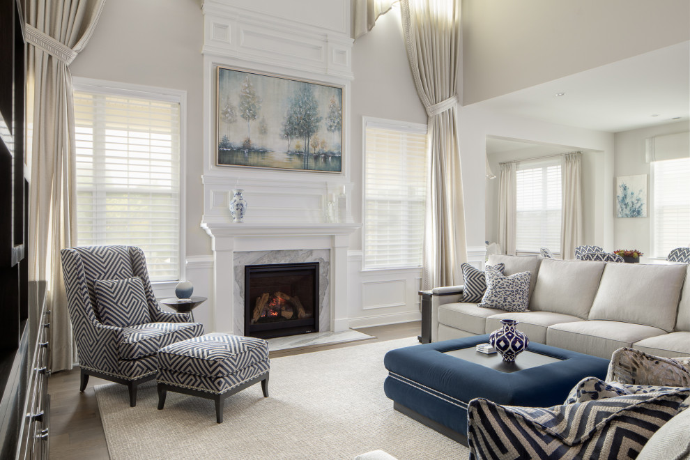 Photo of an expansive classic grey and white open plan living room in Newark with grey walls, medium hardwood flooring, a standard fireplace, a stone fireplace surround, a wall mounted tv, brown floors, a coffered ceiling and wainscoting.