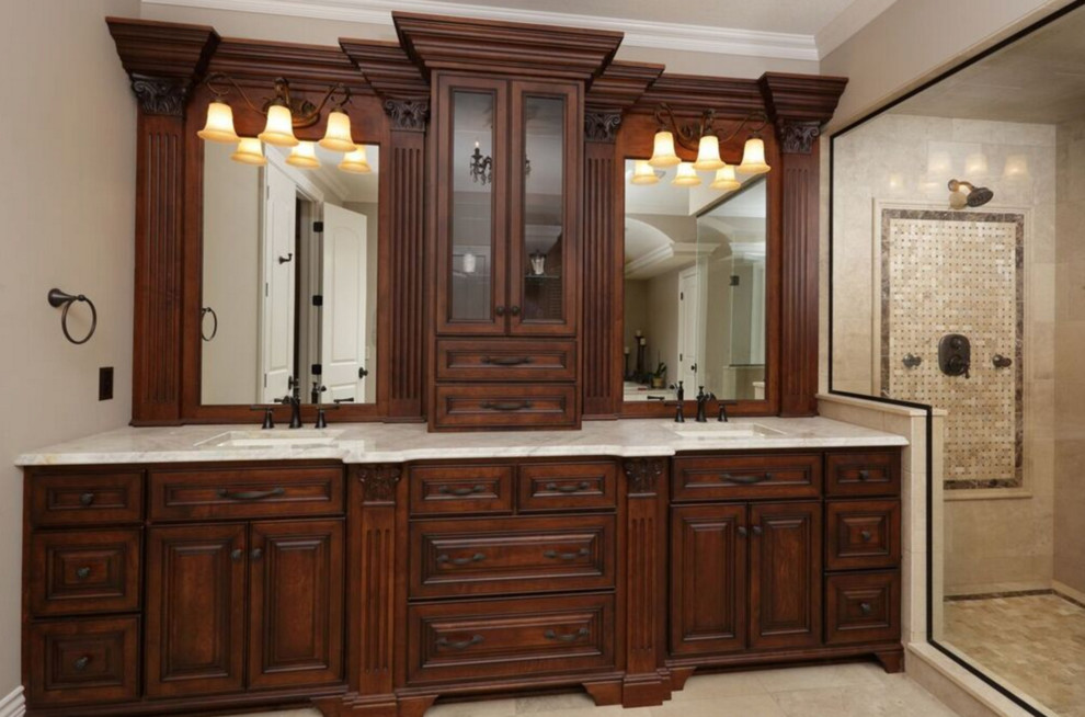This is an example of a large transitional master bathroom in Other with beige tile, beige walls, an undermount sink, raised-panel cabinets, dark wood cabinets, a claw-foot tub, an alcove shower, a one-piece toilet, limestone, limestone floors, granite benchtops, beige floor and a hinged shower door.