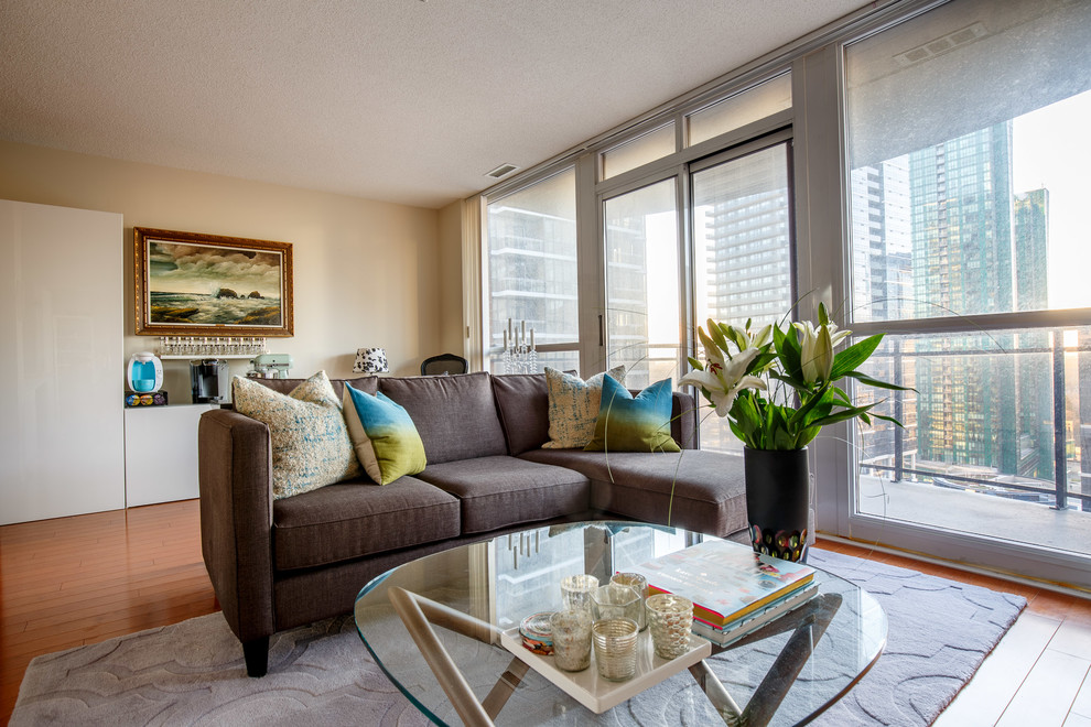 Small trendy open concept medium tone wood floor and brown floor living room photo in Toronto with beige walls, no fireplace and a tv stand
