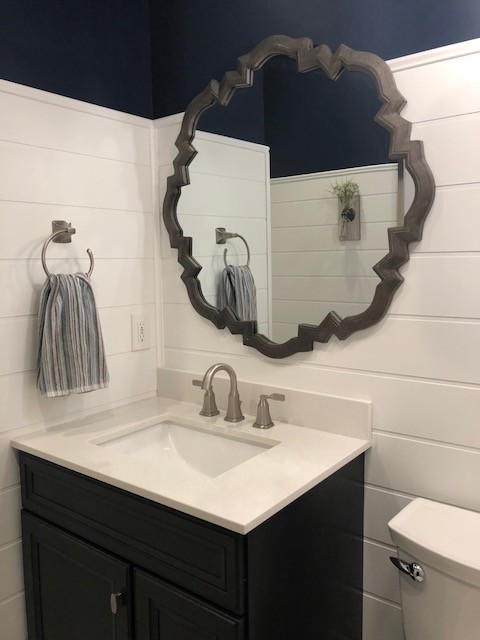 Inspiration for a mid-sized transitional 3/4 porcelain floor and beige floor bathroom remodel in DC Metro with recessed-panel cabinets, black cabinets, a two-piece toilet, blue walls, an undermount sink, engineered quartz countertops and white countertops
