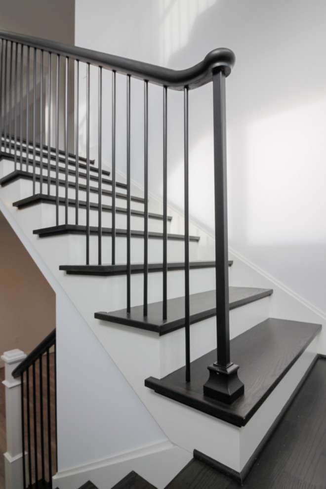 Modelo de escalera suspendida tradicional renovada grande con escalones de madera, contrahuellas de madera, barandilla de varios materiales y panelado