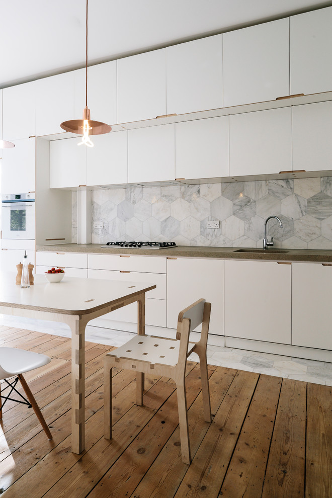Inspiration for a scandinavian single-wall kitchen/diner in London with a built-in sink, flat-panel cabinets, white cabinets, wood worktops, multi-coloured splashback, marble splashback, stainless steel appliances, painted wood flooring, no island, grey floors and brown worktops.