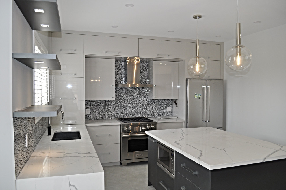 Photo of a mid-sized modern l-shaped eat-in kitchen in Toronto with an undermount sink, flat-panel cabinets, grey cabinets, quartz benchtops, white splashback, mosaic tile splashback, stainless steel appliances, porcelain floors, with island, white floor and white benchtop.