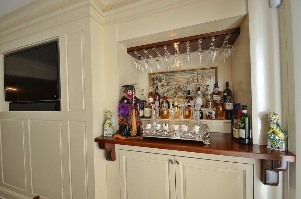 Design ideas for a mid-sized traditional single-wall home bar in New York with no sink, raised-panel cabinets and beige cabinets.