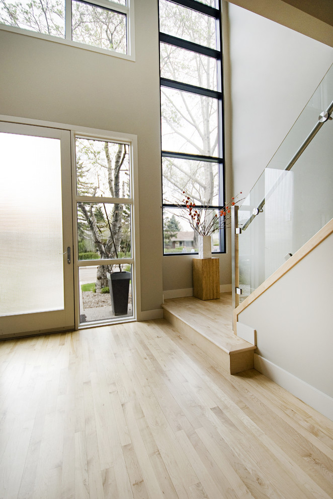 Photo of a contemporary hallway in Calgary with white walls and light hardwood floors.
