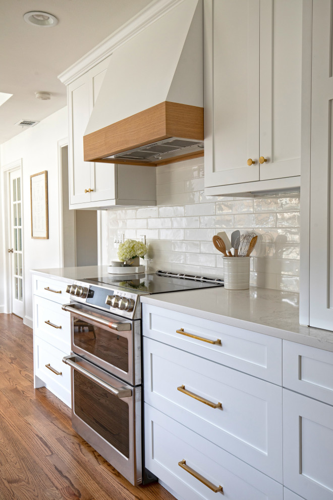 Mid-sized transitional galley medium tone wood floor and brown floor eat-in kitchen photo in Dallas with a farmhouse sink, shaker cabinets, white cabinets, quartz countertops, white backsplash, subway tile backsplash, stainless steel appliances, no island and white countertops