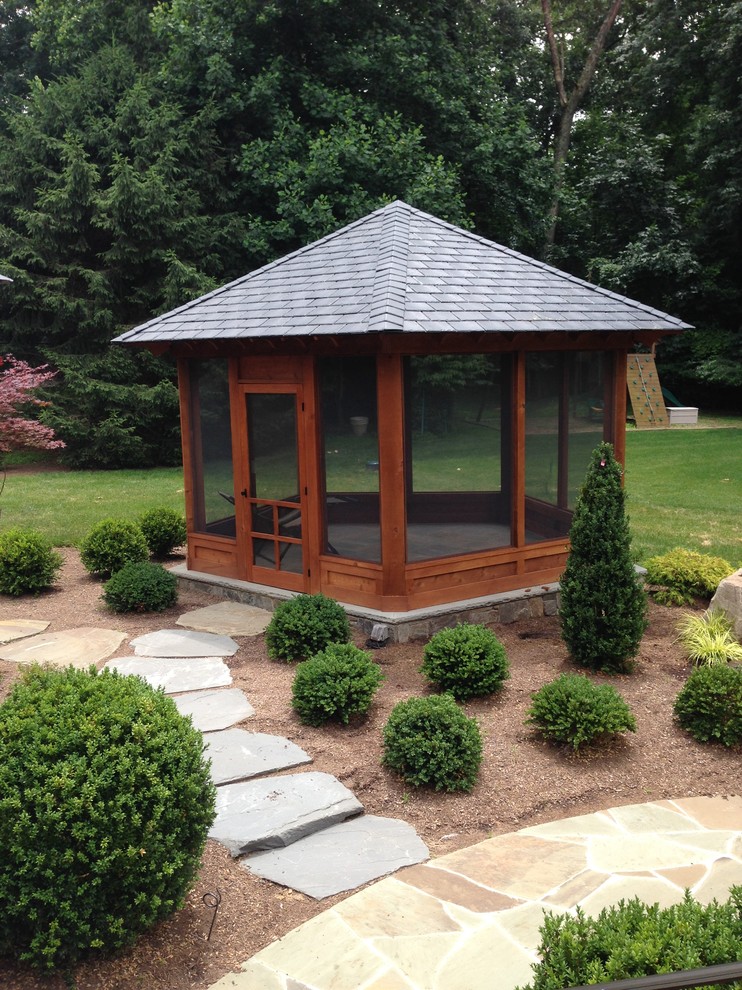Inspiration for a mid-sized contemporary backyard patio in DC Metro with natural stone pavers and a roof extension.
