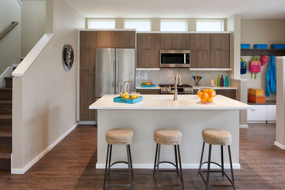 Inspiration for a contemporary galley dark wood floor kitchen remodel in Denver with flat-panel cabinets, dark wood cabinets, gray backsplash, subway tile backsplash, stainless steel appliances and an island