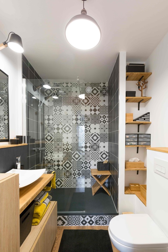Inspiration for a mid-sized contemporary 3/4 bathroom in Paris with a wall-mount toilet, black and white tile, cement tile, white walls, a vessel sink, flat-panel cabinets, light wood cabinets, wood benchtops, an alcove shower, light hardwood floors, an open shower and brown benchtops.