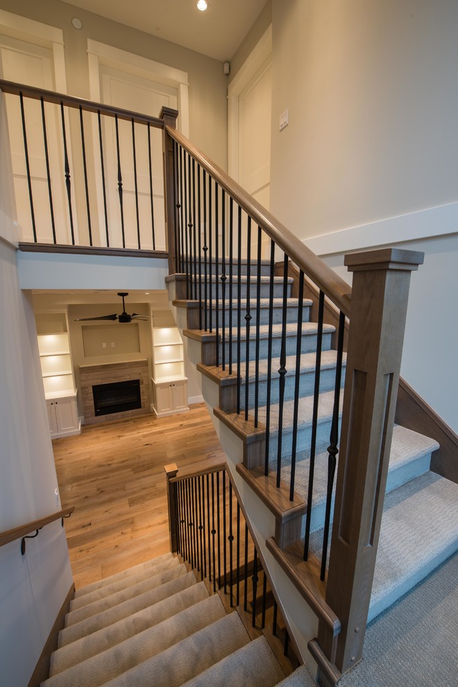 Design ideas for a mid-sized traditional carpeted u-shaped staircase in Vancouver with carpet risers and wood railing.