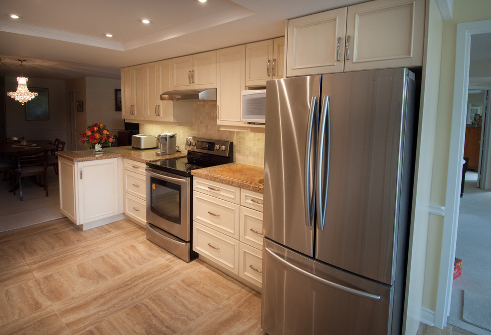 Inspiration for a mid-sized transitional u-shaped vinyl floor eat-in kitchen remodel in Toronto with a double-bowl sink, recessed-panel cabinets, white cabinets, granite countertops, beige backsplash, ceramic backsplash, stainless steel appliances and no island