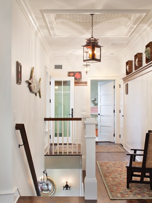 Inspiration for a large beach style hallway in New York with white walls, dark hardwood floors and brown floor.