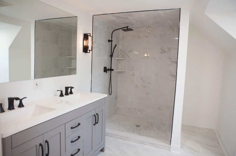Photo of a mid-sized transitional 3/4 bathroom in New York with shaker cabinets, grey cabinets, a corner shower, gray tile, marble, white walls, marble floors, an undermount sink, solid surface benchtops, grey floor and white benchtops.