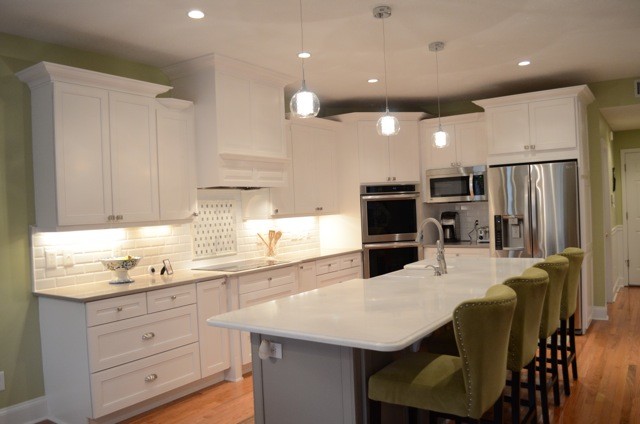 Kitchen - large transitional medium tone wood floor kitchen idea in Jacksonville with a farmhouse sink, shaker cabinets, white cabinets, quartzite countertops, white backsplash, ceramic backsplash, stainless steel appliances, green walls and an island