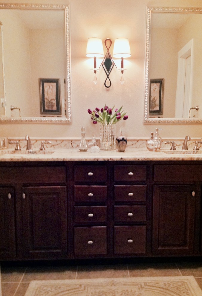 Mid-sized traditional master bathroom in Dallas with an undermount sink, raised-panel cabinets, dark wood cabinets, granite benchtops, an alcove tub, an alcove shower, a two-piece toilet, beige tile, porcelain tile, beige walls and porcelain floors.