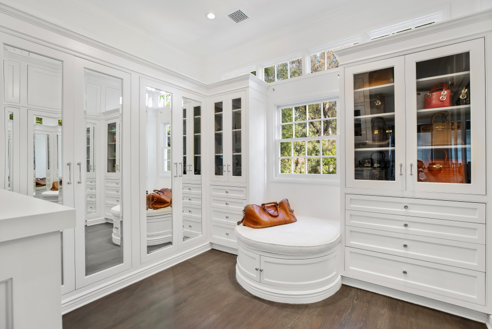 This is an example of a transitional walk-in wardrobe in Los Angeles with beaded inset cabinets, white cabinets, dark hardwood floors and brown floor.