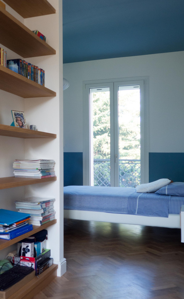 Exemple d'une très grande chambre d'enfant éclectique avec un mur bleu, parquet foncé et boiseries.