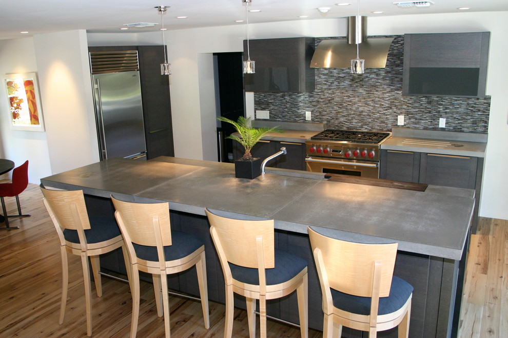 Design ideas for a mid-sized contemporary single-wall eat-in kitchen in Phoenix with concrete benchtops, an undermount sink, grey cabinets, multi-coloured splashback, matchstick tile splashback, stainless steel appliances, light hardwood floors, with island, beige floor and grey benchtop.