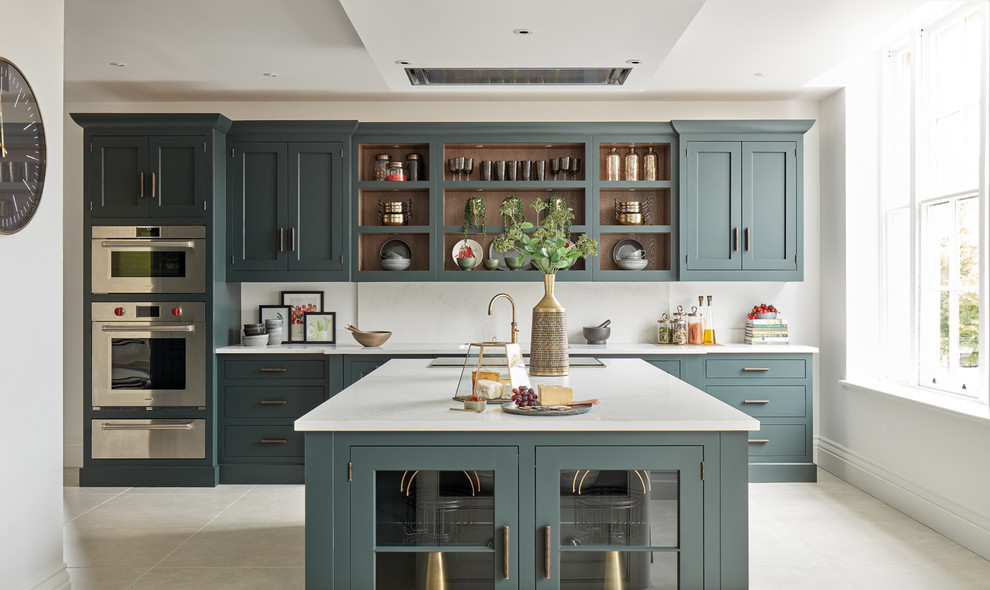 Design ideas for a mid-sized traditional single-wall eat-in kitchen in Gloucestershire with a drop-in sink, shaker cabinets, green cabinets, quartzite benchtops, white splashback, stainless steel appliances, limestone floors, with island, beige floor and white benchtop.