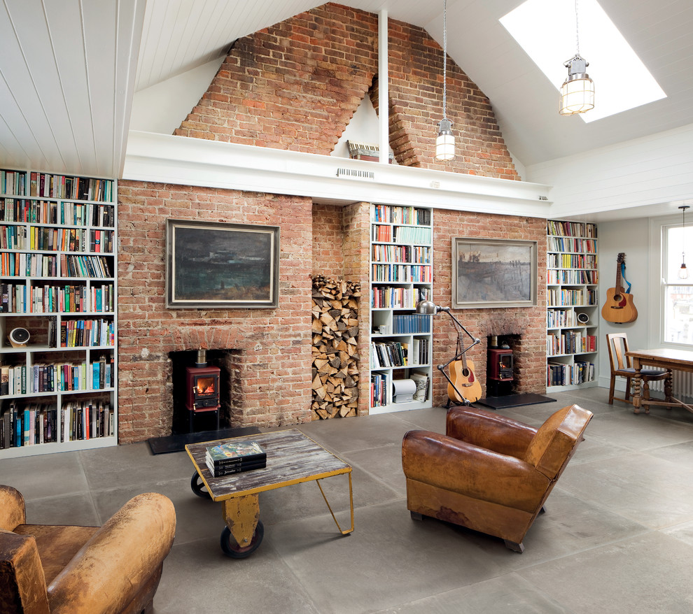 Industrial open concept family room in Vancouver with a library, white walls, a wood stove and a brick fireplace surround.