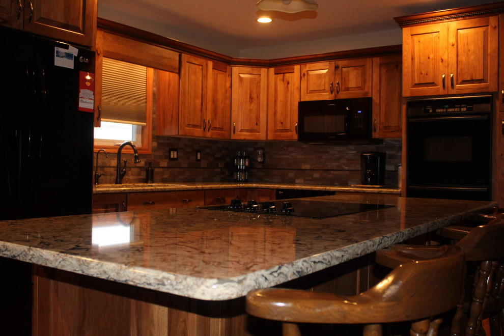 Open concept kitchen - large rustic l-shaped medium tone wood floor and brown floor open concept kitchen idea with an undermount sink, raised-panel cabinets, brown cabinets, quartzite countertops, metallic backsplash, black appliances, an island and brown countertops