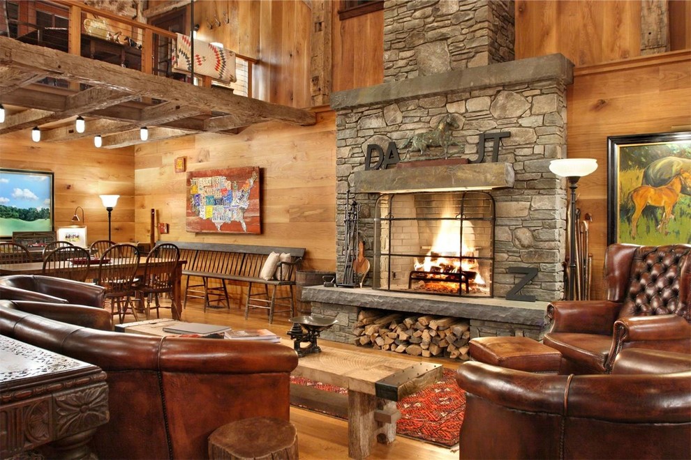Inspiration for a large country open concept living room in New York with medium hardwood floors, a standard fireplace, a stone fireplace surround, no tv and brown floor.