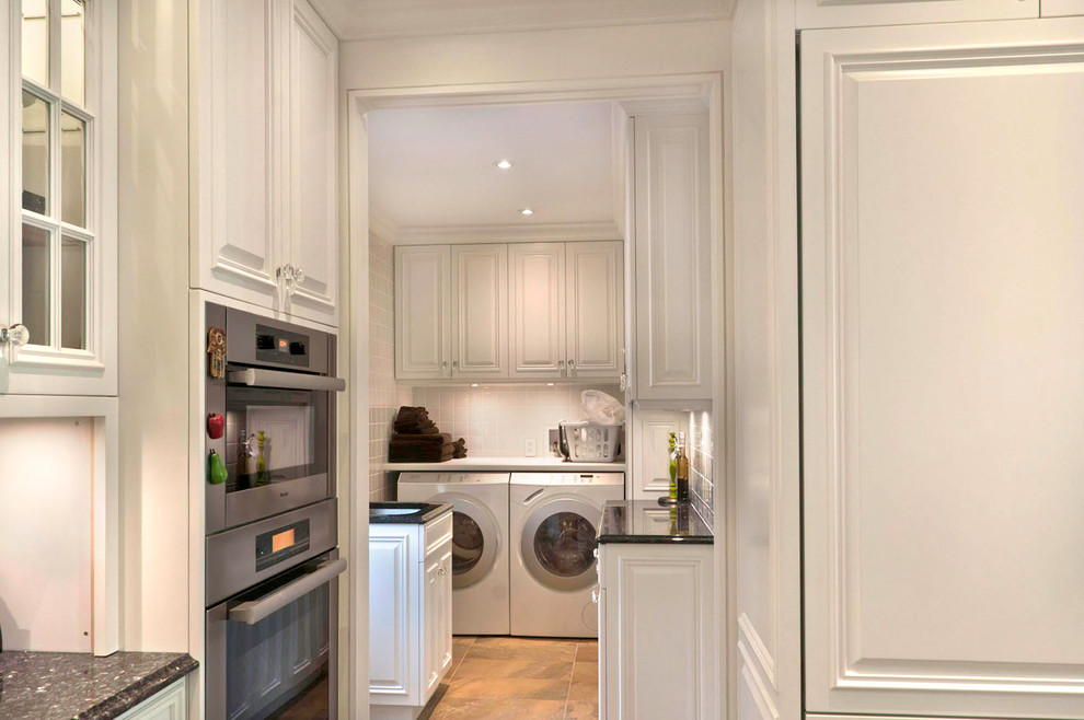Small traditional u-shaped dedicated laundry room in Montreal with an undermount sink, raised-panel cabinets, white cabinets, granite benchtops, white walls, slate floors, a side-by-side washer and dryer and multi-coloured floor.