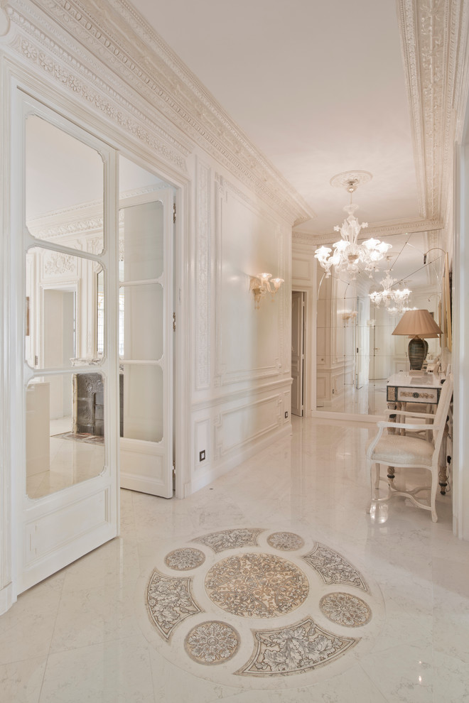 This is an example of a large transitional hallway in Paris with beige walls and marble floors.